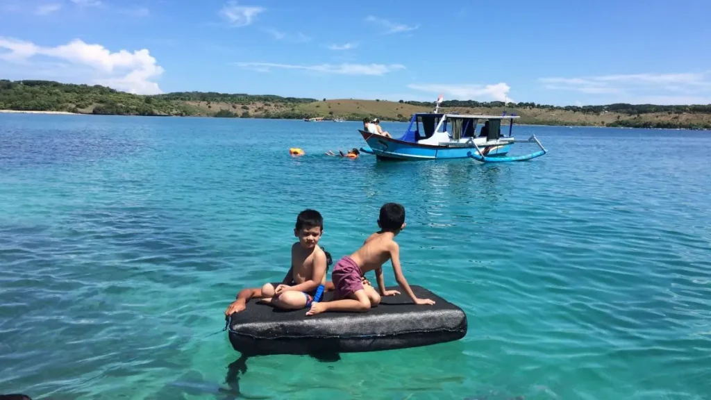 Keseruan anak-anak bermain di air jernih Pantai Pink Lombok dalam Paket Tour Lombok 2 Hari 1 Malam