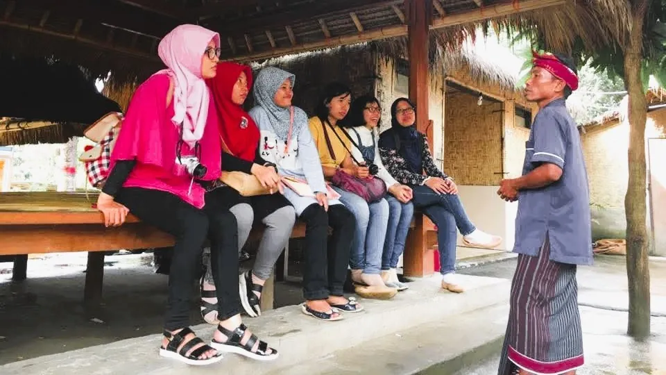 Wisatawan tengah mendengarkan pemaparan tentang Desa Sade oleh lokal Guide - Itinerary Hari 1 Paket Tour Lombok 3H2M B