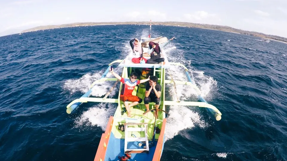 Wisatawan menikmati pemandangan laut saat menuju Pantai Pink menggunakan private boat - Itinerary Hari 2 Paket Tour Lombok 3H2M D
