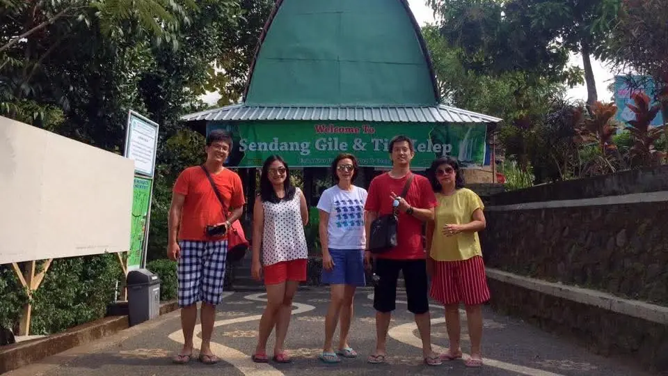 Wisatawan berfoto di gerbang masuk Air Terjun Tiu Kelep, Senaru – Itinerary Hari 2 Paket Tour Lombok 4H3M E