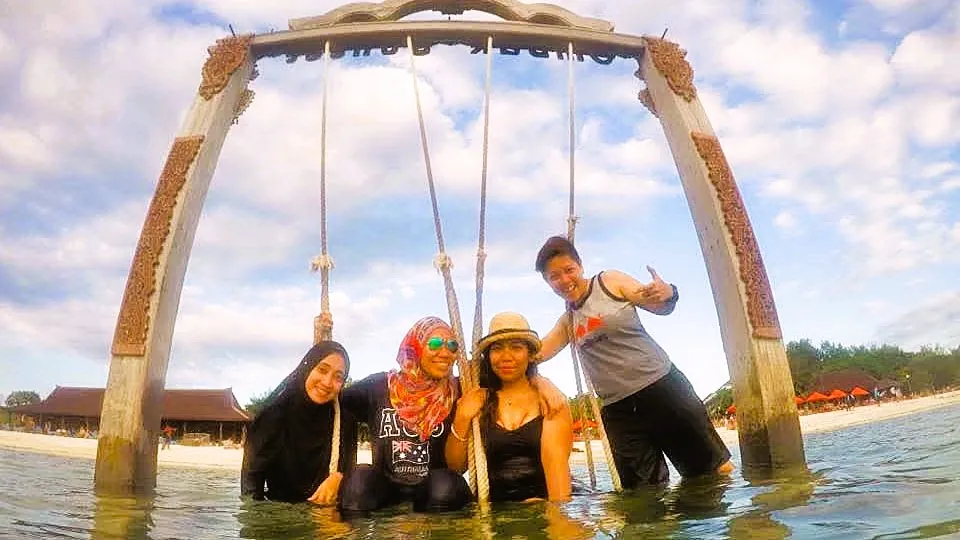 Wisatawan berfoto di ayunan pantai Gili Trawangan Lombok – Itinerary Paket Tour Sehari Gili Trawangan