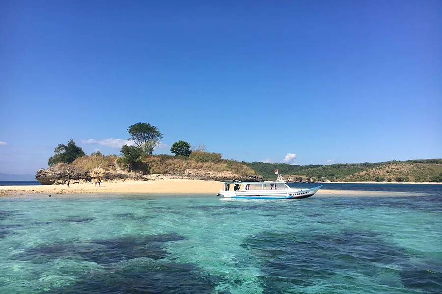 Pulau kecil dan boat di air jernih Lombok, Paket Tour Lombok 5 Hari 4 Malam B